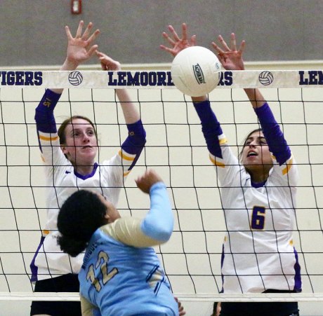 Maddelyn Kelly and Alexis Ramponi block a shot against Monache.